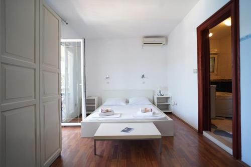 a white bedroom with a white bed and a door at Sea House Mljet in Polače