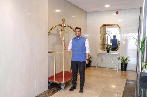 a man standing next to a shower in a room at SIRIUS TOWER in Juffair