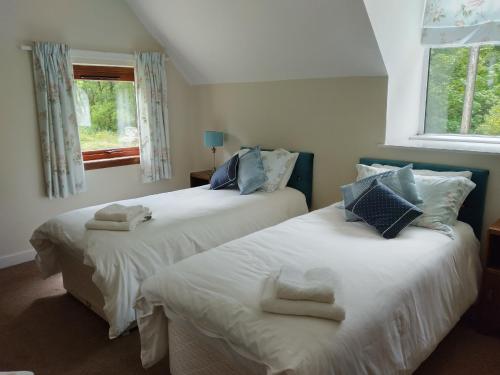 a bedroom with two beds with towels on them at Beautiful Farm House at the foot of Ben More. in Crianlarich