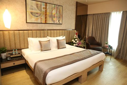 a bedroom with a large bed in a hotel room at The Regenza By Tunga in Navi Mumbai