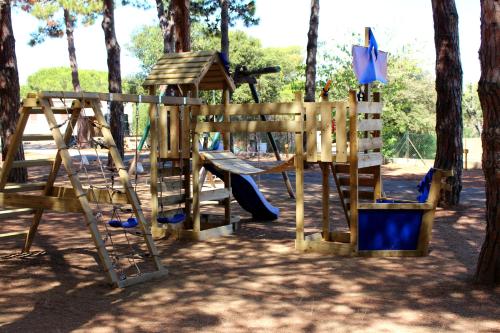 une aire de jeux en bois avec un toboggan et une balançoire dans l'établissement Résidence Tramariccia, à Calvi