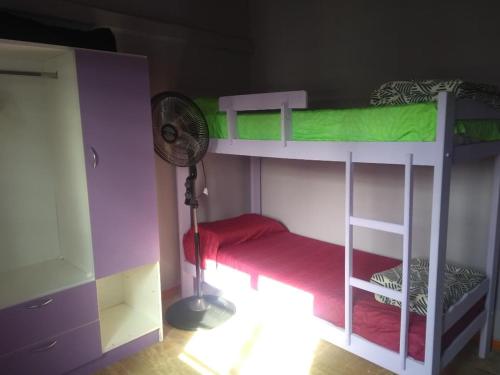 1 dormitorio con 2 literas y ventilador en casa lila 2cuadras del mar en Balneario Mar Azul