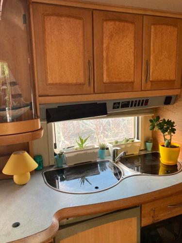 a kitchen counter with a sink and a microwave at Синеморец Каравана Paradise in Sinemorets