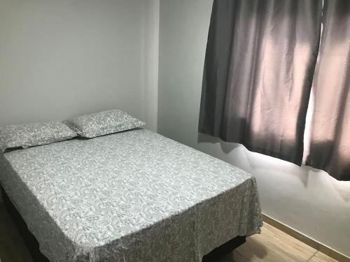 een klein bed in een kamer met een raam bij Casa com 2 quartos agradáveis com ar condicionado in Foz do Iguaçu