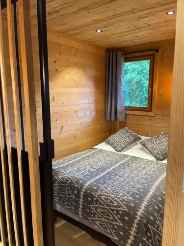 Demi-QuartierにあるMarmotte du Jaillet Cosy and charmant appartementの木造キャビン内のベッド1台が備わるベッドルーム1室を利用します。
