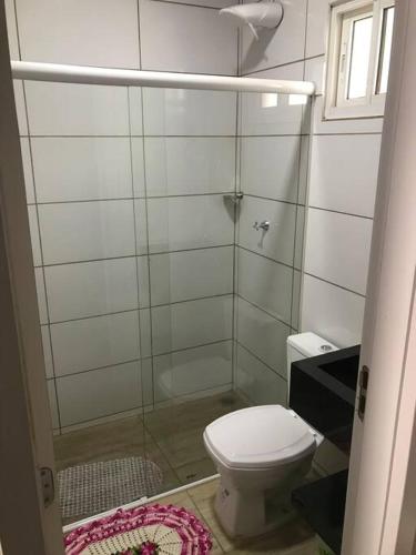 a small bathroom with a toilet and a shower at Casa com 2 quartos agradáveis com ar condicionado in Foz do Iguaçu