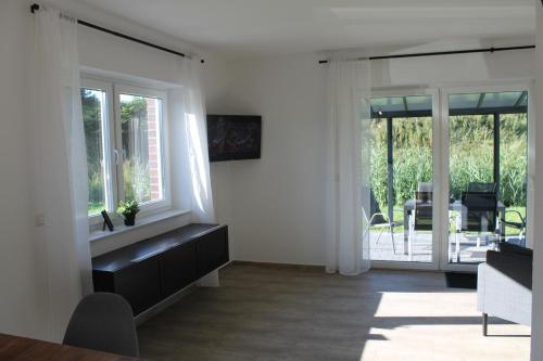uma sala de estar com uma grande janela e uma mesa em Ferienhaus am Seedeich em Emden