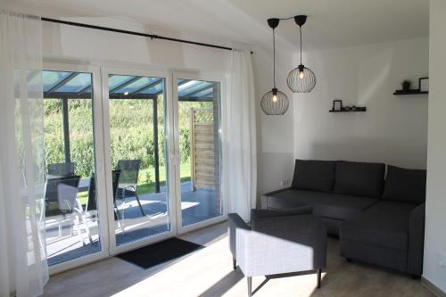 a living room with a couch and a sliding glass door at Ferienhaus am Seedeich in Emden