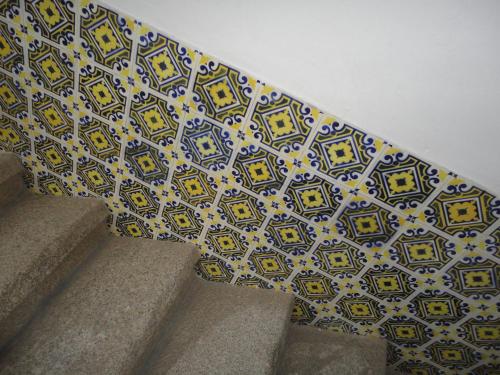 a wall with a tile pattern on a stair case at Hotel Solar de Monfalim in Évora