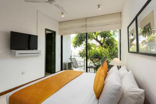a bedroom with a large bed with a tv and a window at Rockwell Colombo in Colombo