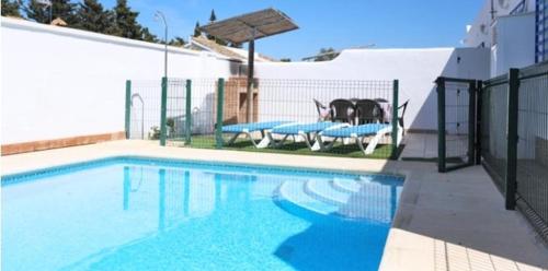 una piscina con due tavoli da picnic e un cane di Casa Enrique a Cadice