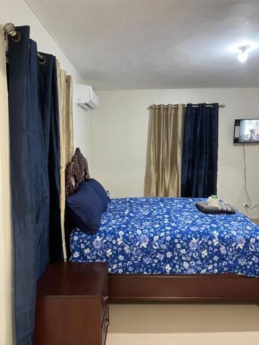 a bedroom with a bed with a blue comforter at Luxury Apartment "Santo Domingo Este" in San Isidro