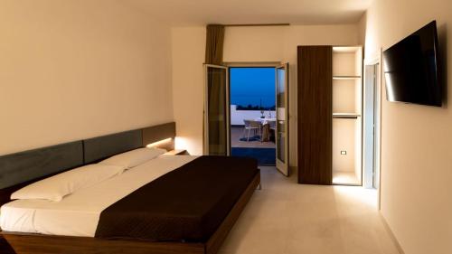 1 dormitorio con cama y vistas a un balcón en Terrazza sul Mare, en Roseto degli Abruzzi