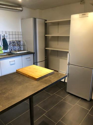 a kitchen with a table with a refrigerator and shelves at 3-rumslägenhet i villa med havsutsikt i Båstad Hindbärsvägen 22 in Båstad
