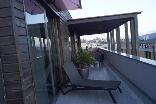 a balcony with a chair and a potted plant at Hotel Tuta in Tbilisi City