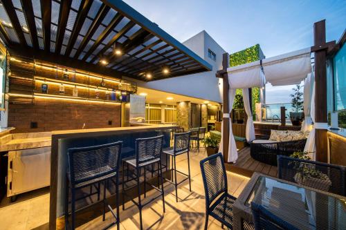 a patio with chairs and a bar on a deck at Hotel Meridional in Fortaleza