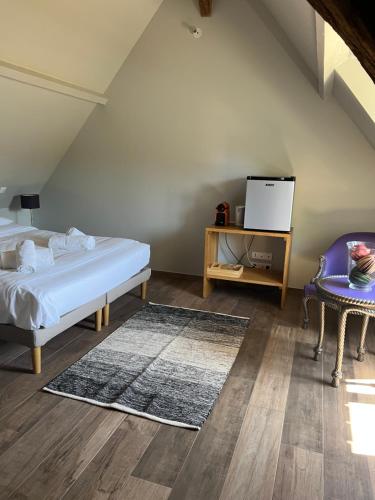 een slaapkamer met een bed, een tafel en een stoel bij Le domaine des Bois in Blangy-le-Château