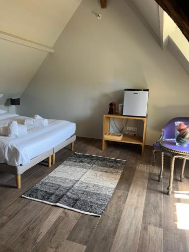 une chambre avec un lit, une table et une chaise dans l'établissement Le domaine des Bois, à Blangy-le-Château