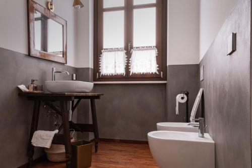 a bathroom with two sinks and a toilet at Dimora Ferraris in Càbras