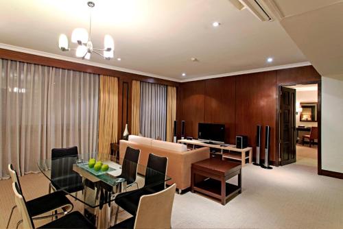 a dining room and living room with a dining table at Cebu Parklane International Hotel in Cebu City