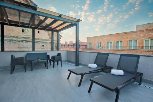 a patio with chairs and tables on a roof at Hotel Tuta in Tbilisi City