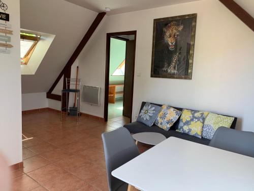 ein Wohnzimmer mit einem Sofa und einem Tisch in der Unterkunft Appartement situé prés des plages et du golf in Saint-Briac-sur-Mer