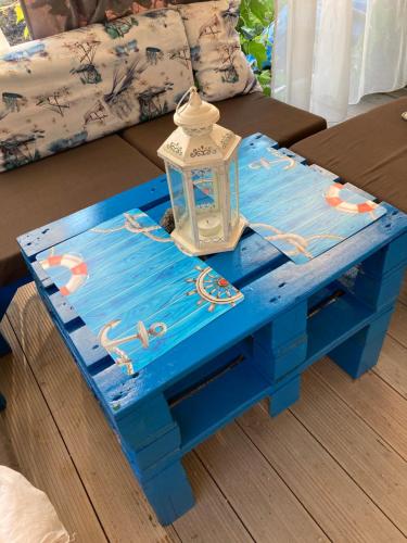 een blauwe salontafel met een lantaarn erop bij Синеморец Каравана Paradise in Sinemorets