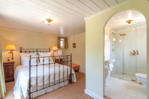 a bedroom with a bed and a walk in shower at De Heerlijkheid Loenen Bed en Breakfast in Slijk-Ewijk