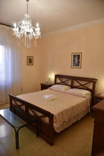 1 dormitorio con cama y lámpara de araña en My House en Loreto