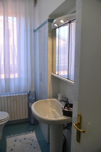 a bathroom with a sink and a toilet and a window at My House in Loreto