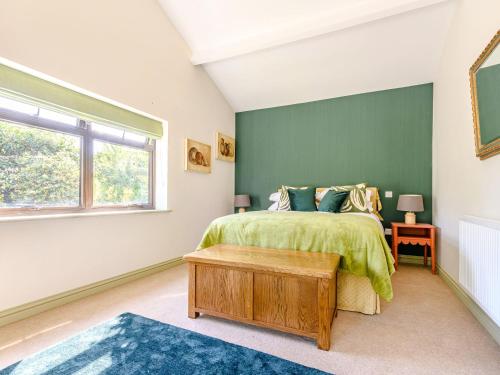 1 dormitorio con cama y pared verde en The Paddock, en Shipston on Stour