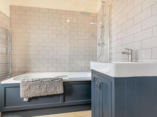 a bathroom with a blue sink and a tub at The Paddock in Shipston-on-Stour