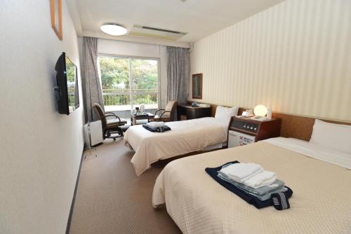 a hotel room with two beds and a window at Yataro in Nagasaki