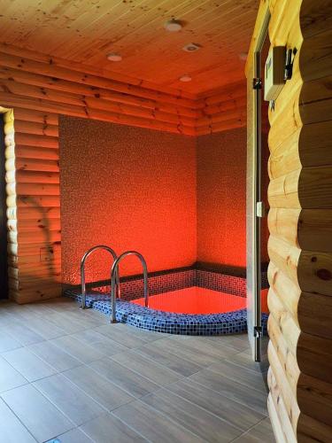 a room with a hot tub in a red wall at Knyazhyi Dvir in Myslivka