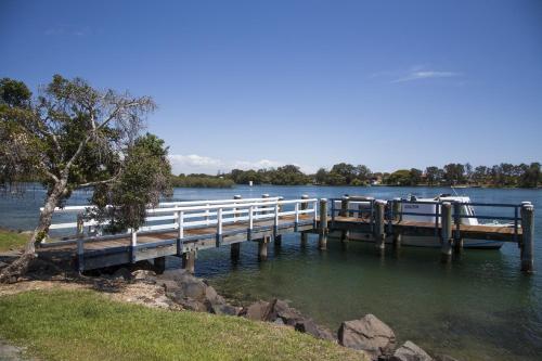 a dock on a lake with boats on the water at Colonial Tweed Holiday & Home Park in Tweed Heads
