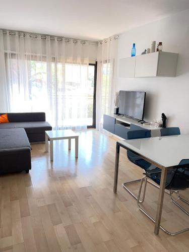 een woonkamer met een tafel en een bank bij Sunny apartment Sa Boadella big solarium sea view in Lloret de Mar
