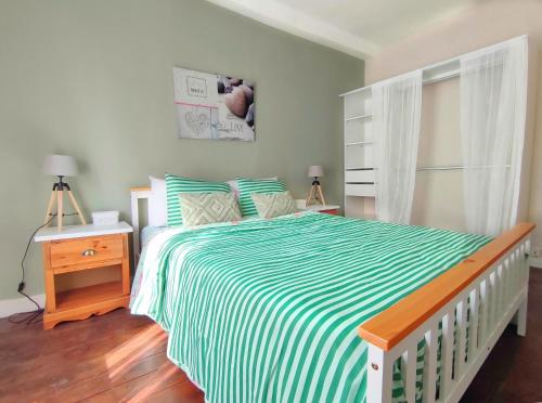 1 dormitorio con 1 cama con manta de rayas verde y blanca en Number 22 - Le Dorat - Apartment 3, en Le Dorat