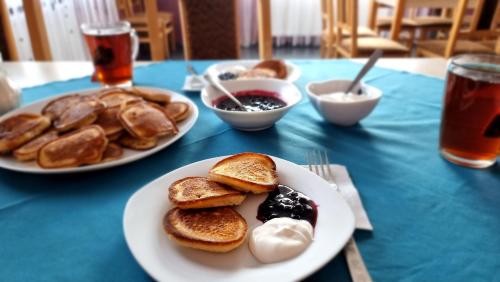 una mesa con dos platos de tortitas y otros alimentos en Manchela садиба en Vygoda