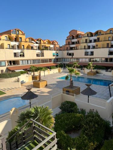 - une vue aérienne sur un complexe avec une piscine et des bâtiments dans l'établissement Escale à Gruissan au coeur de la Marina, à Gruissan