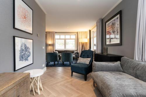 a living room with a couch and a table at Grand Hotel Opduin in De Koog