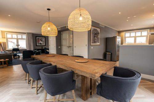 a dining room with a wooden table and chairs at Grand Hotel Opduin in De Koog