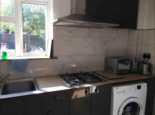 a kitchen with a stove top oven next to a microwave at Nikolay’s House in Bristol