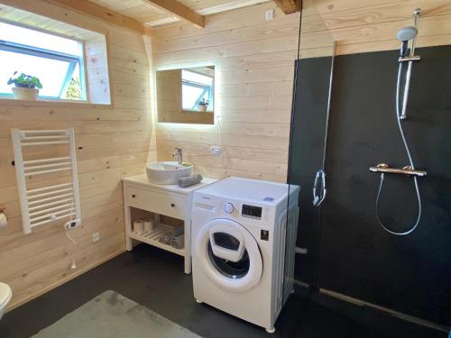 a bathroom with a washing machine and a sink at Hyggehytten auf Bornholm in Østermarie
