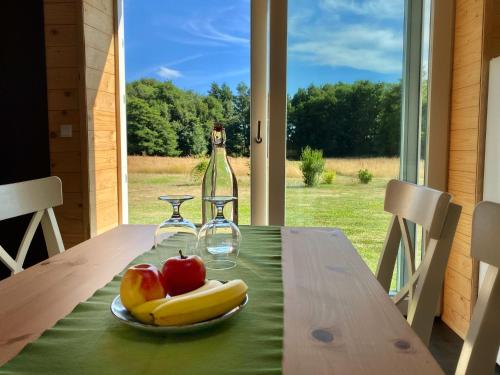 a table with a plate of fruit and a bottle of wine at Hyggehytten auf Bornholm in Østermarie