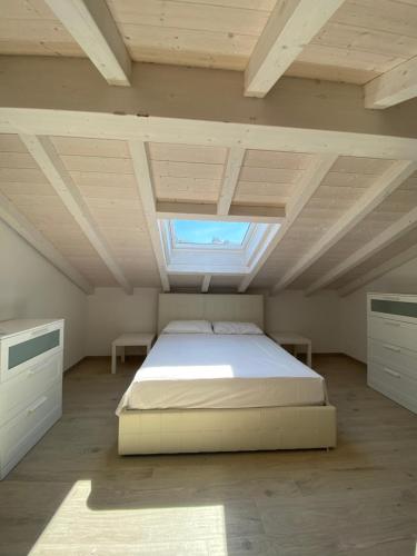 a large bedroom with a bed and a skylight at Around Lago Maggiore apartments in Reno Di Leggiuno