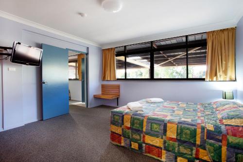 a bedroom with a bed and a window at Vale Hotel in Townsville