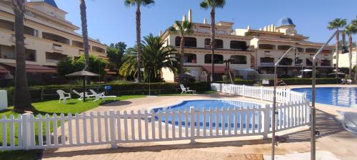 una valla blanca frente a un edificio con piscina en Costa Ballena!!! House on Mediterranean Coast with pool and golf!!! Dúplex!!!, en Costa Ballena