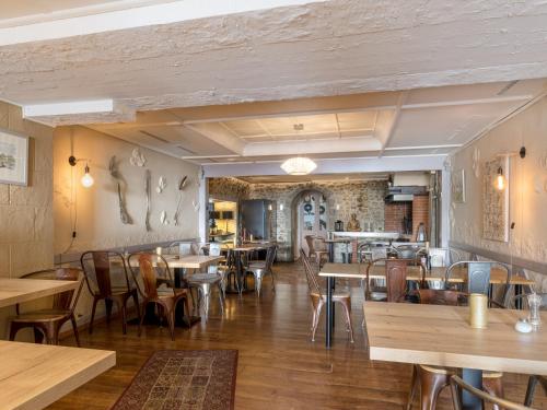 a dining room with wooden tables and chairs at L'Hôtel by Hostellerie du Château in Rolle