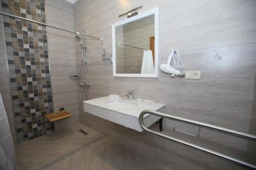 a bathroom with a sink and a shower with a mirror at Auroom Hotel in Baku