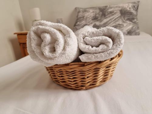 a basket filled with towels sitting on a bed at Mamina's House in il-Baħrija
